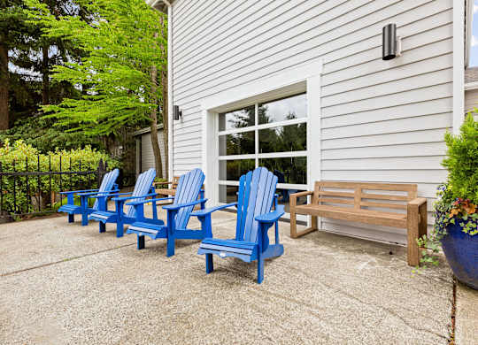 A set of blue chairs are arranged on a patio.