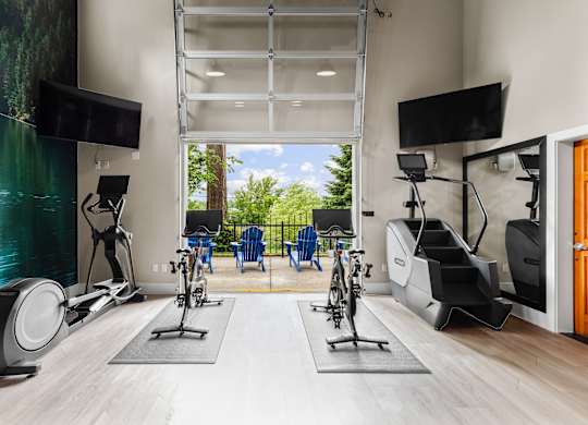A home gym with exercise equipment and a television.