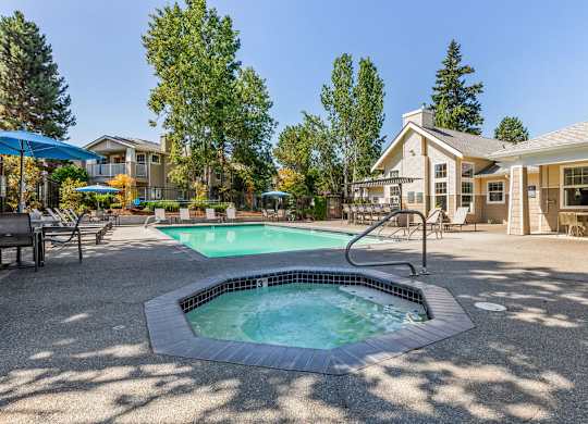 A small pool with a hot tub in the middle of a patio.