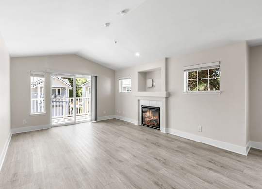 A spacious living room with a fireplace and sliding glass doors.