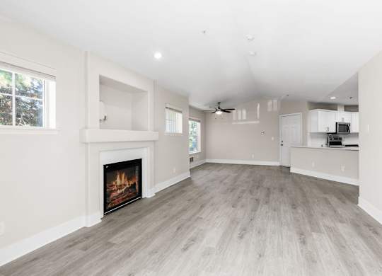 A spacious living room with a fireplace and hardwood floors.