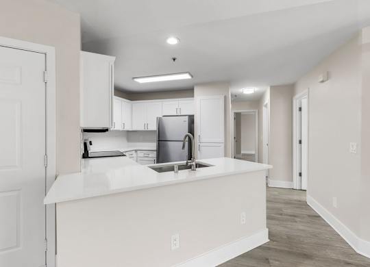 A kitchen with white cabinets and a white countertop.