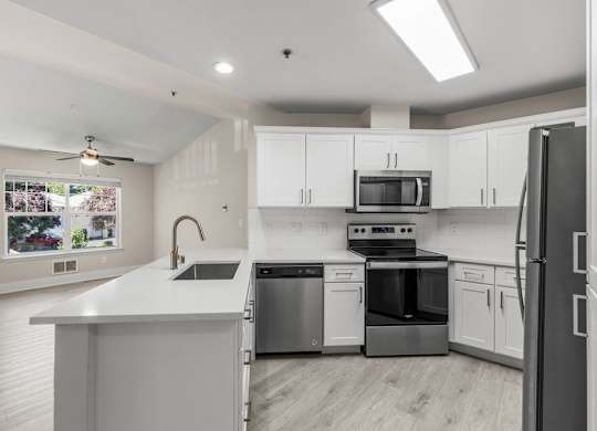 A modern kitchen with stainless steel appliances and white cabinets.