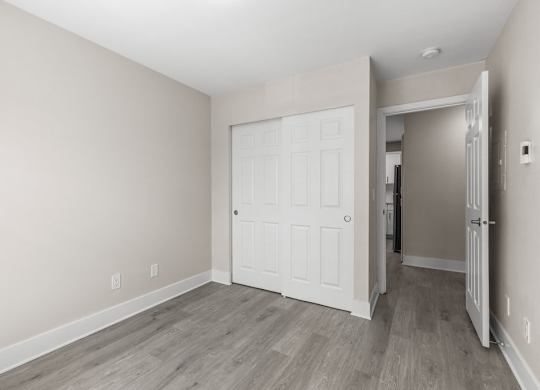 A room with a white door and a grey floor.