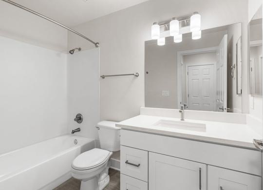 A white bathroom with a toilet, sink, and bathtub.