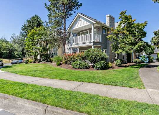 A house with a well-maintained lawn and a clear sky.