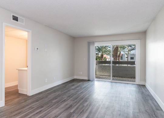 A room with a sliding glass door leading to a balcony.
