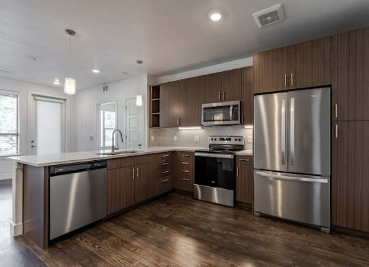 A modern kitchen with wooden cabinets and stainless steel appliances.