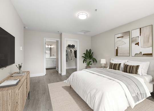 A bedroom with a large bed, a wooden nightstand, and a TV on the wall.