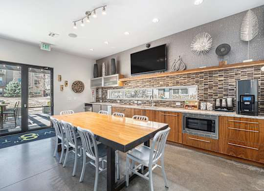 A modern kitchen with a wooden table and chairs.