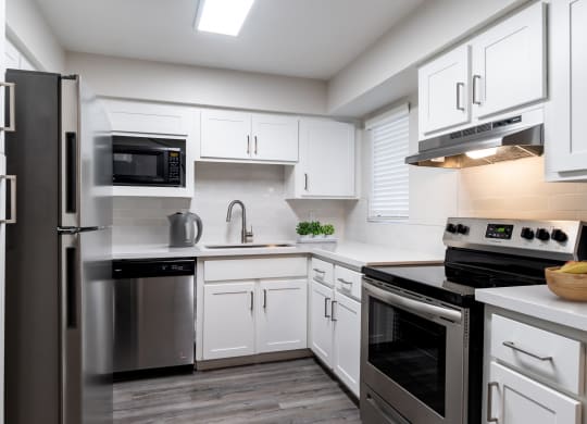 a kitchen with white cabinets and stainless steel appliances