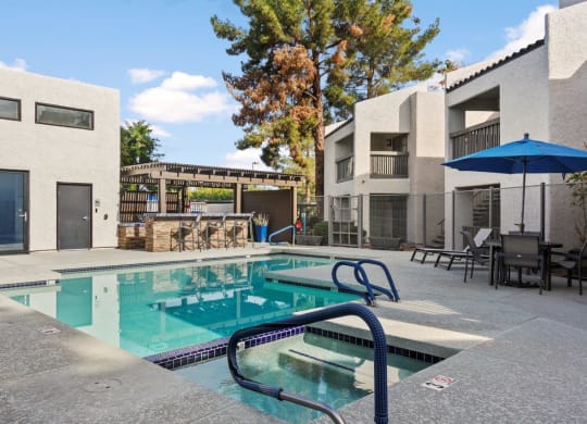 Del Sol Apartments Pool with Lounge Chairs and BBQ Area