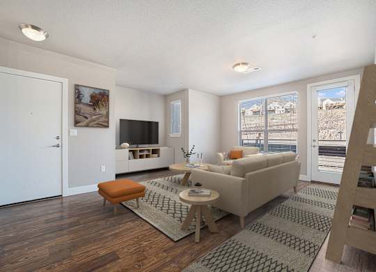 A living room with a couch, a chair, a coffee table, and a television.