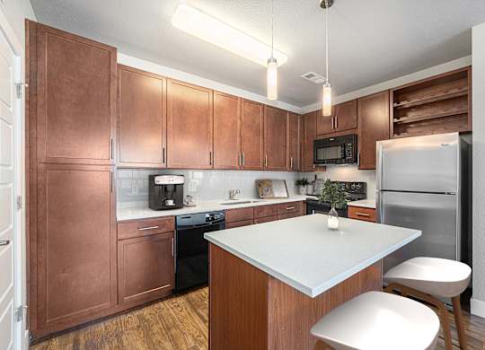 A kitchen with brown cabinets and a white island.