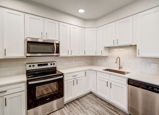 a kitchen with white cabinets and stainless steel appliances