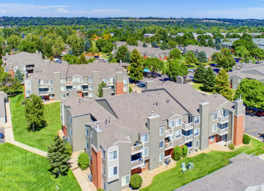 an aerial view of an apartment complex with green grass and trees