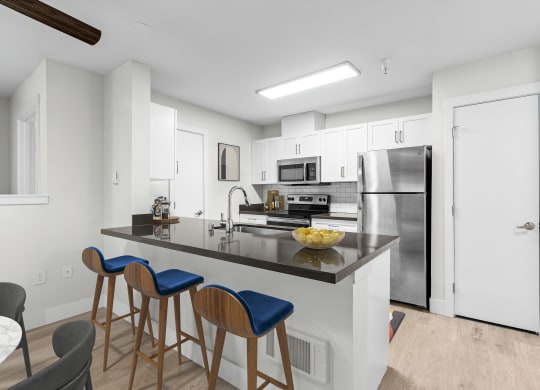 a kitchen with a large center island with a breakfast bar and three stools