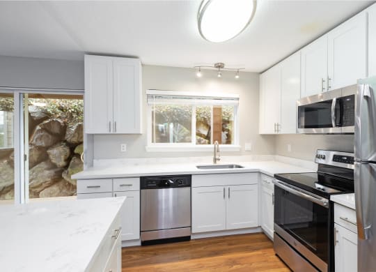 a kitchen with white cabinets and stainless steel appliances