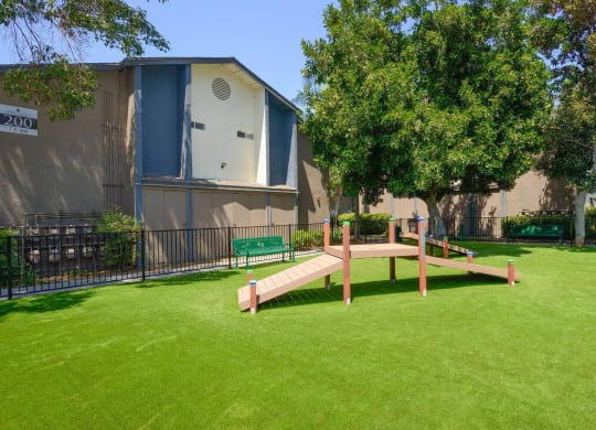 a park with a bench and trees in front of a building