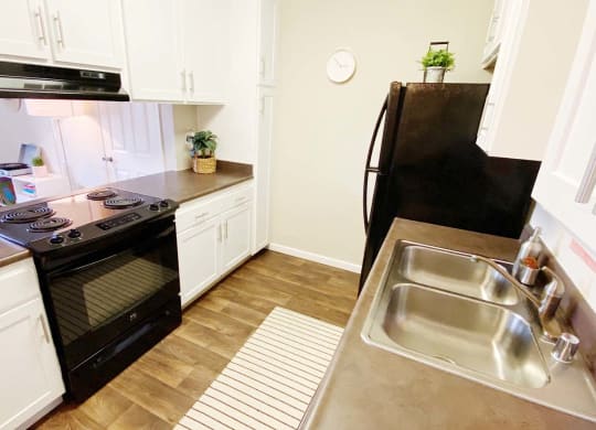 a kitchen with white cabinets and black appliances