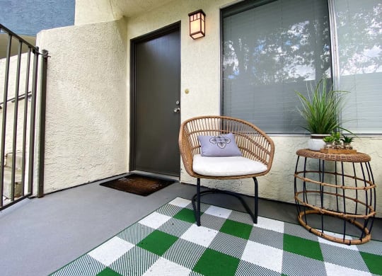 a front porch with a chair and a side table