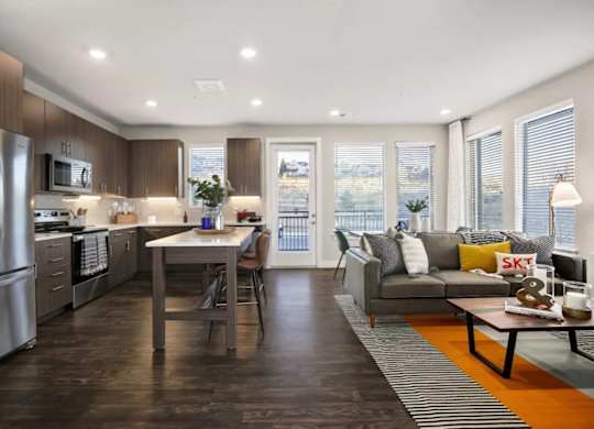 A modern kitchen with a dining table and a couch.