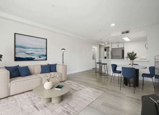 a living room with white walls and a white couch with blue pillows