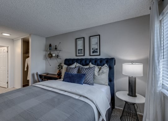 a bedroom with a bed and a nightstand with a lamp