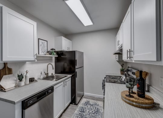 a kitchen with white cabinets and stainless steel appliances