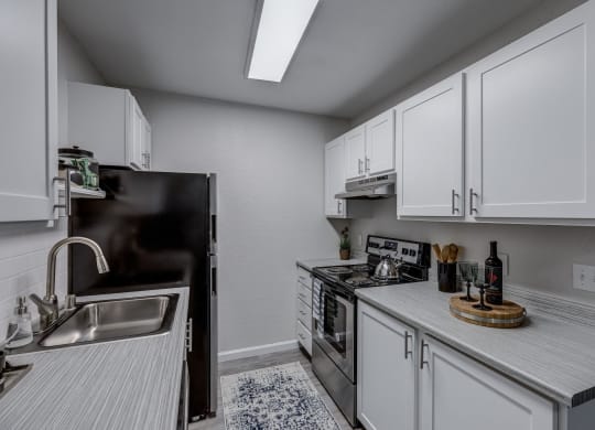 a kitchen with white cabinets and stainless steel appliances