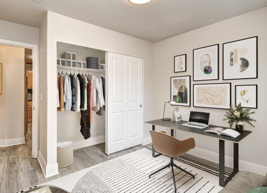 a closet in a bedroom with a desk and chair