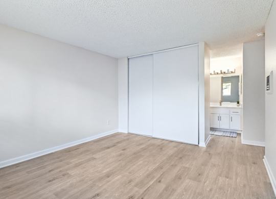A room with a white wall and a white closet door.