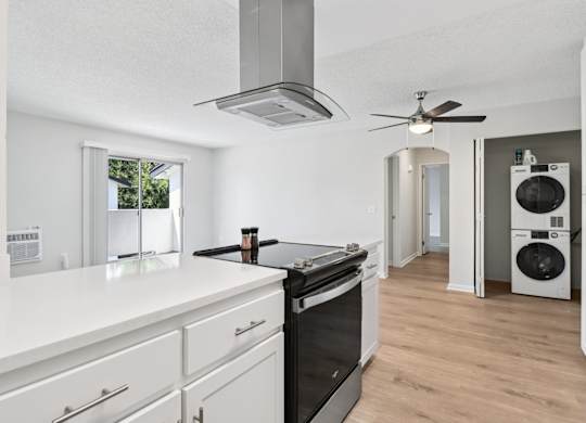 A modern kitchen with white cabinets and a black countertop.