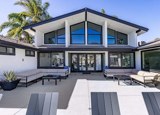 A modern house with a white exterior and a large glass window.