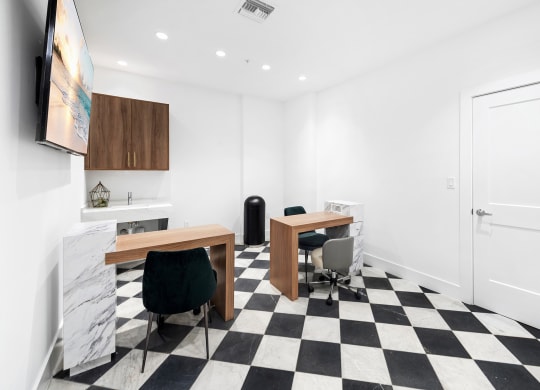 a room with a checkerboard floor and two desks