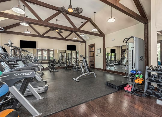 a gym with cardio equipment and weights