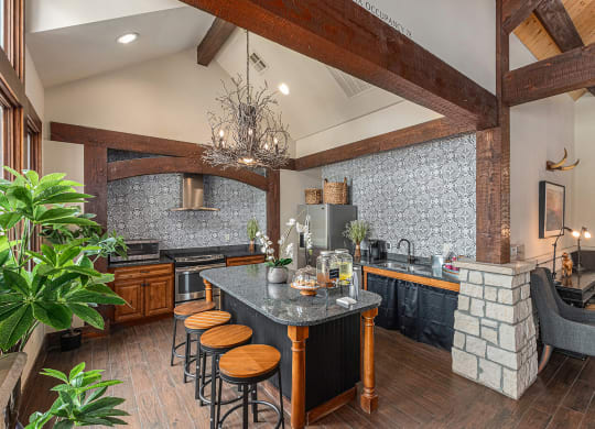 a kitchen with a long island with stools and a fireplace