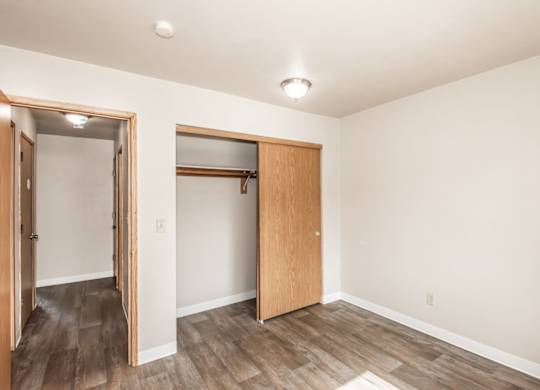 A room with a wooden floor and a white ceiling with a light fixture.