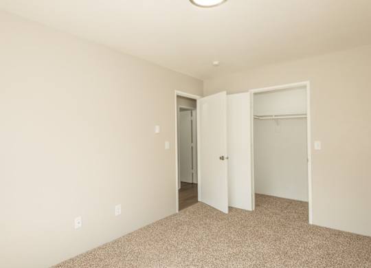 A room with a carpeted floor and a white door.
