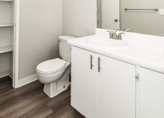 A white bathroom with a toilet, sink, and medicine cabinet.