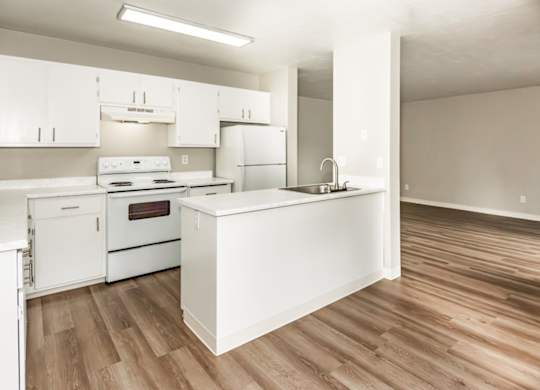 A kitchen with white appliances and wooden floors.