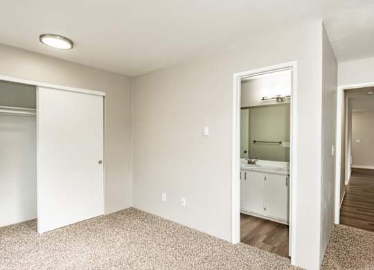 A white bathroom with a white door and a white cabinet.