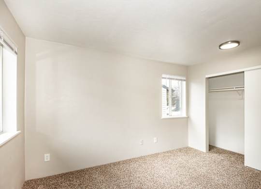 A room with a carpeted floor and a window.