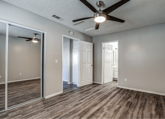 an empty living room with a ceiling fan at Aspire Seneca, Victorville, CA
