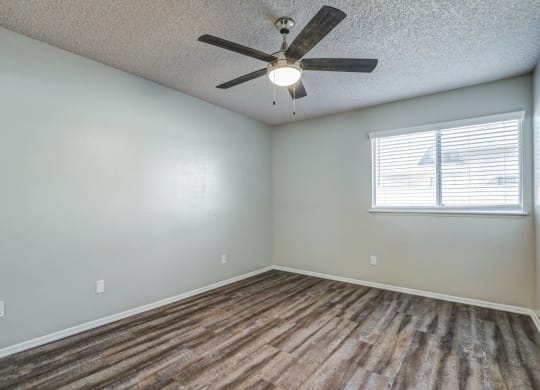 an empty living room with a ceiling fan and a windowat Aspire Seneca, Victorville, CA