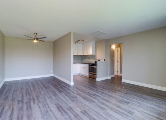 Colton Apartments for Rent - Las Brisas Living Room with Stylish Decor, Beige and Grey Walls, Plank Flooring, Large Window, and Popcorn Ceiling at Las Brisas Apartments, Colton, CA