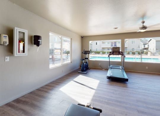 Fitness Center with an Exercise Bike, Treadmills, and View of the Pool at Aspire High Desert Apartments, Victorville, CA, 92392