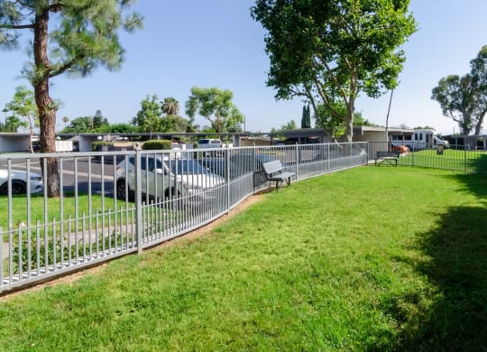 a yard with a fence and benches in a park at Aspire Corona, California, 92882