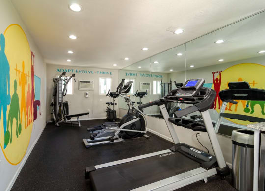 a gym with treadmills and other exercise equipment in a building with colorful walls at Aspire Corona, Corona, 92882