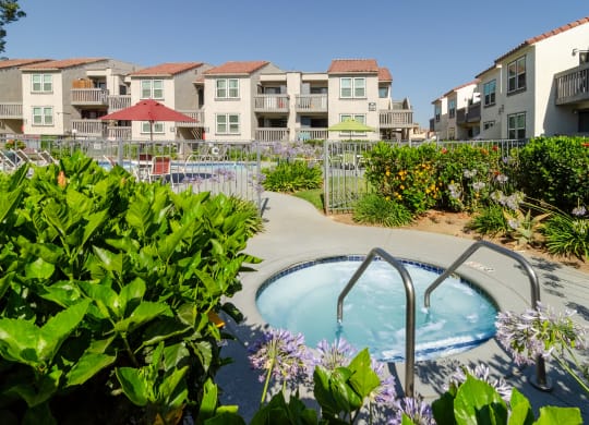 a jacuzzi tub in a garden with apartments in the background at Aspire Corona, Corona, California